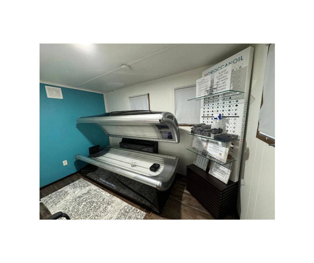 Indoor tanning bed in a small room with blue wall.