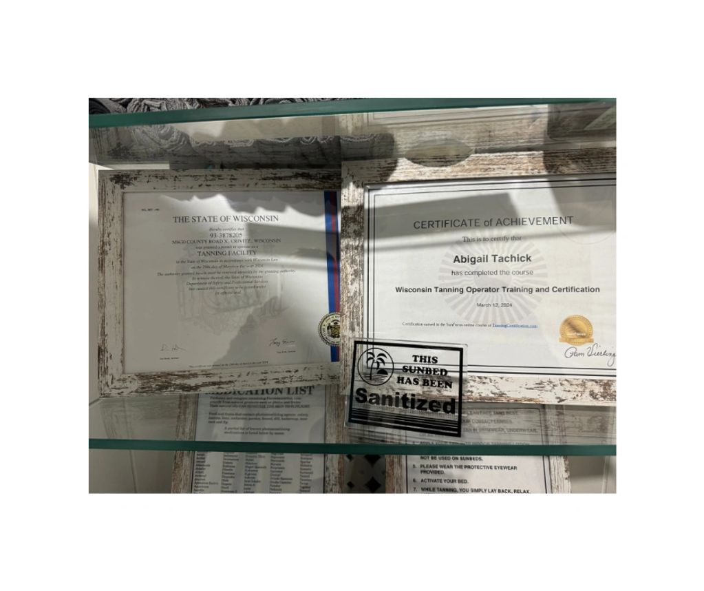 Certificates displayed behind glass on a shelf.