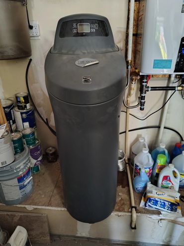 Gray existing water softener before replacement.