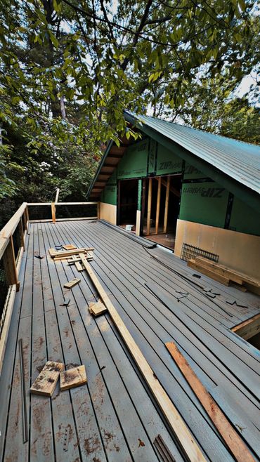 A partially constructed wooden deck attached to a house under construction.
