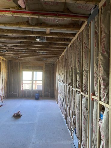 Room under construction with exposed insulation and wooden framing.
