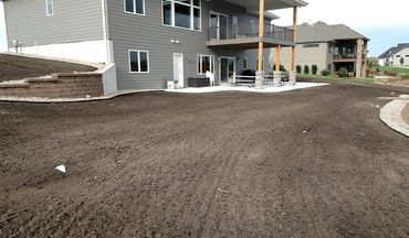 Fresh final graded property with a modern house, preparing for landscaping.