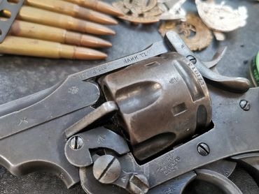 Close-up of a vintage revolver with bullets and badges.