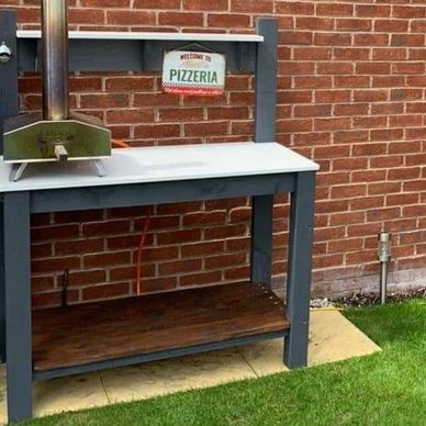 An outdoor pizza oven preparation station with quartz top and grey timber framing