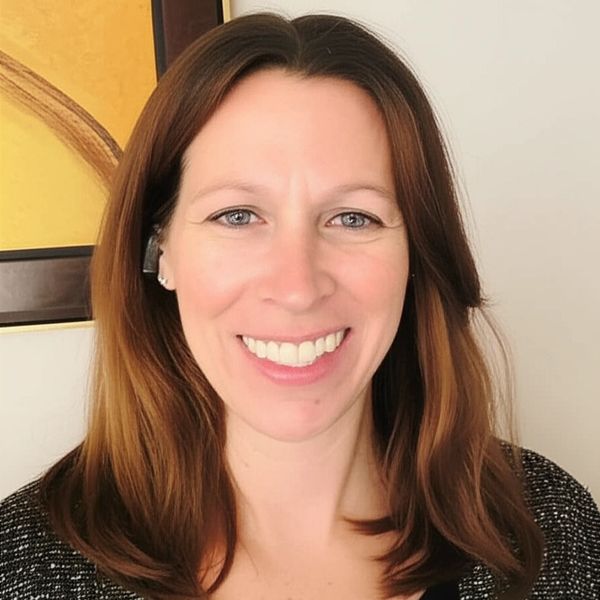 Close-up of a smiling woman with brown hair.