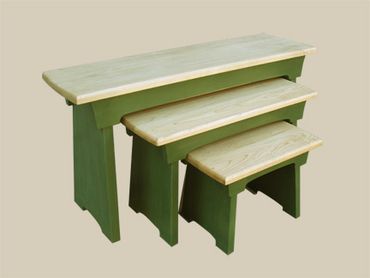 Three wooden nested benches in green and natural wood.