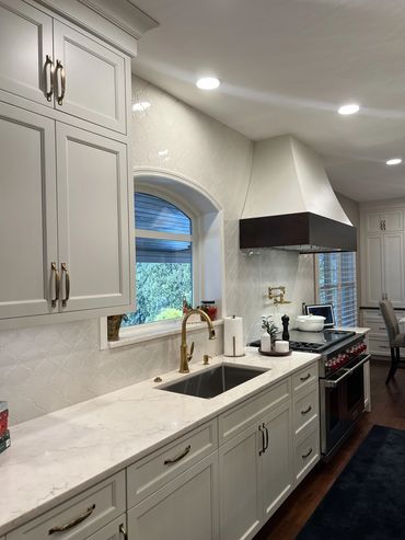 This sink elevation features custom cabinetry and a custom two-toned decorative hood.