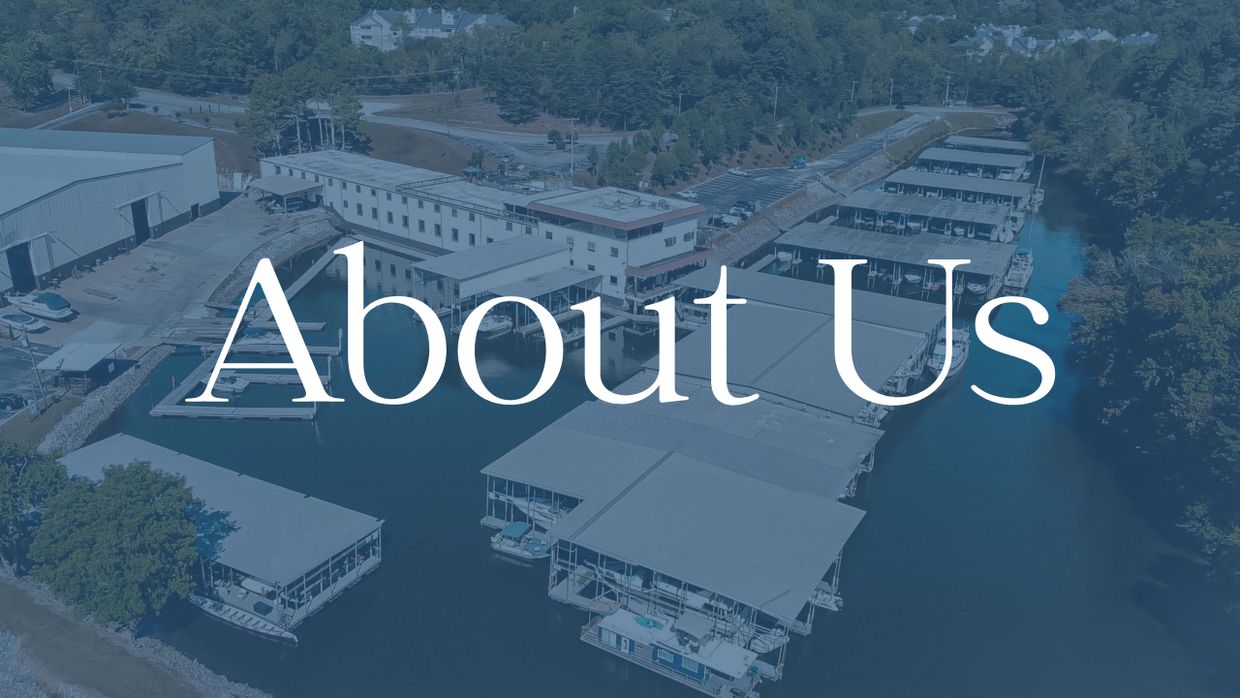 Aerial view of a waterfront marina with the text 'About Us' overlayed.