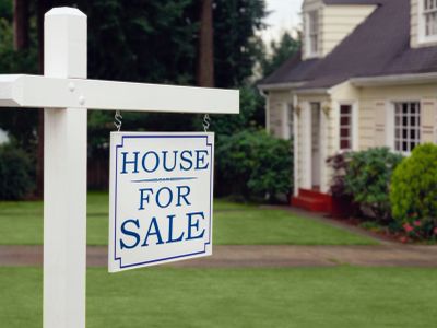 For Sale sign in front of house.