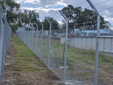 Cranked post and 4 rows of barbed wire security fence
