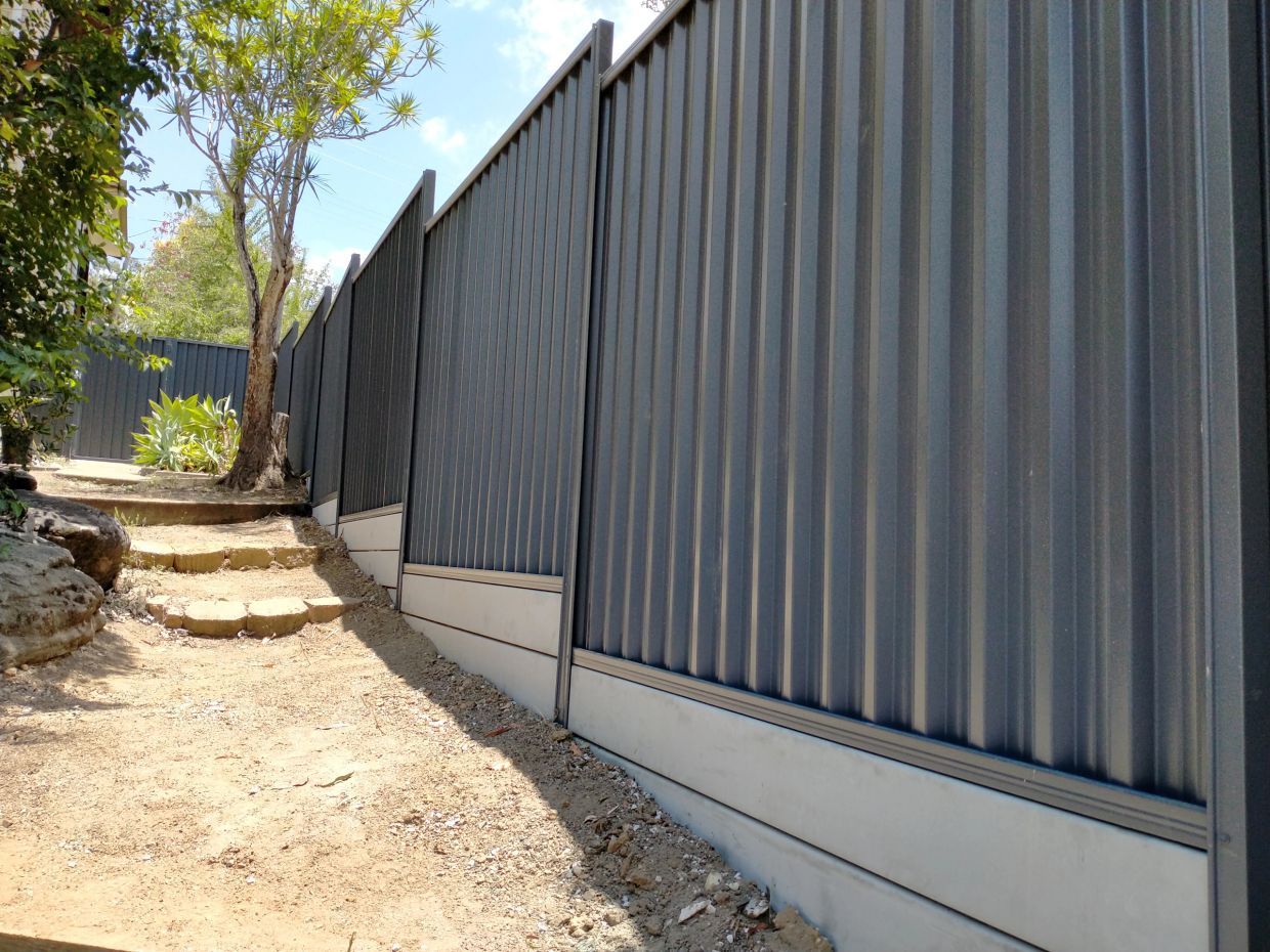 Metal fence along a dirt path with steps.