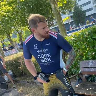 Athlete adjusting triathlon suit outdoors.