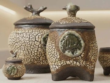 Set of rustic ceramic pots with textured crackled glaze and lids.