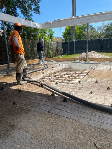 two men finishing concrete on slab