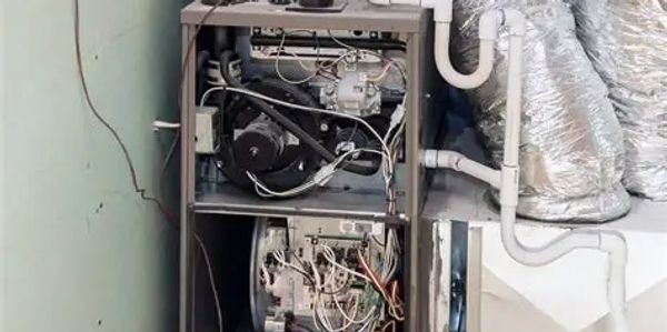 Open HVAC unit showing internal components and wiring with duct connections.