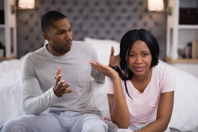 A couple sitting and fighting
