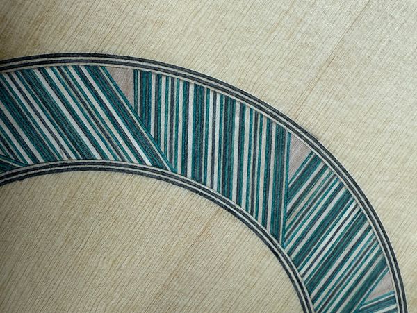 Intricate blue and white striped pattern on a light wood surface.