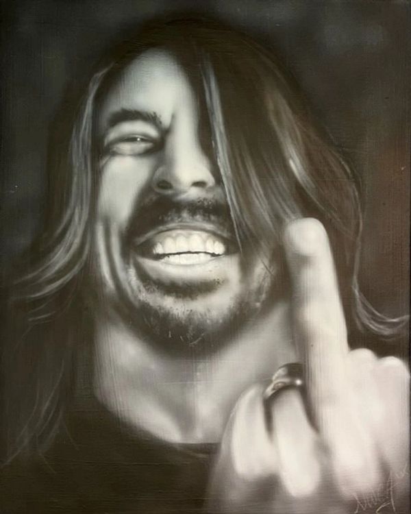 Black and white portrait of a man smiling and showing his middle finger.