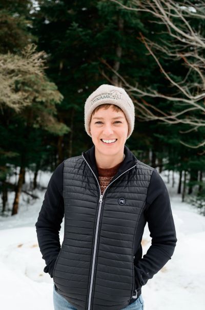 Smiling woman in winter wear outdoors.
