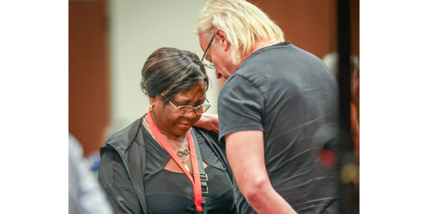Two people in a thoughtful conversation, one wearing a name badge.