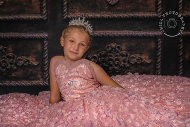 photo of a young girl wearing a tiara in a full pink dress