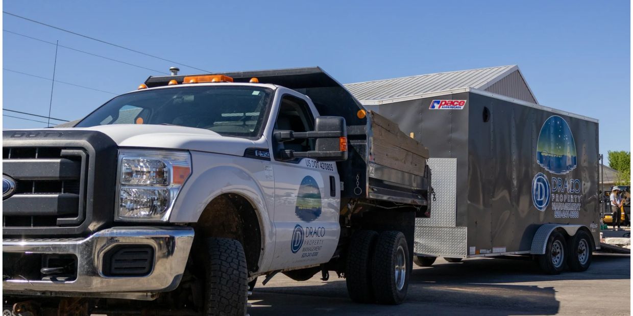 Work truck and trailer with Draco Property Management logo.