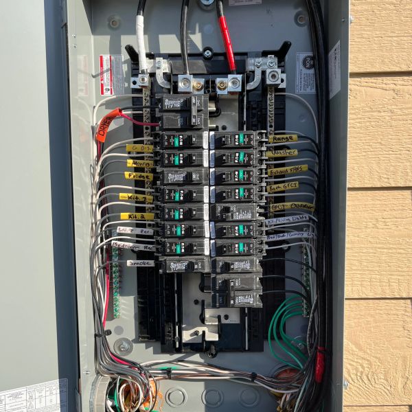 Open electrical panel with labeled circuit breakers.