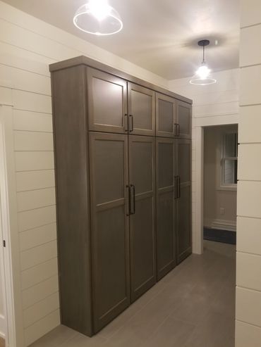 Stained maple tall cabinets with metal mesh panels to allow damp clothes to dry