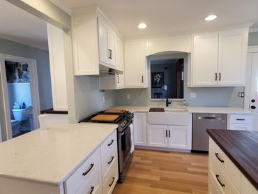 Painted cabinetry with wrap around peninsula featuring walnut butcherblock island countertop