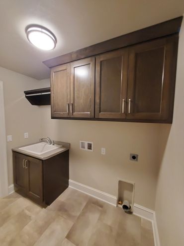 Small laundry room with deep sink and hanging storage above