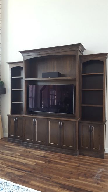 Dark stained maple entertainment center with arched upper cabinet openings