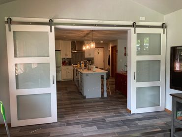 Glass paneled painted barn doors from sunroom to remodeled kitchen 