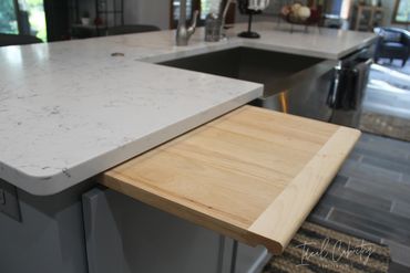 Cutting board above trash pull-out