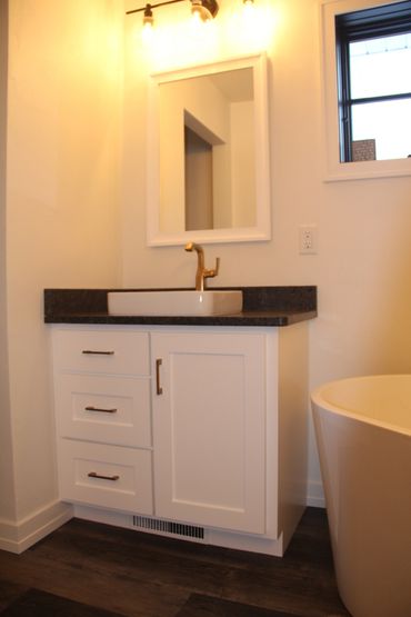 Painted vanity with flat panel door and drawer fronts with black quartz countertop and backsplashes