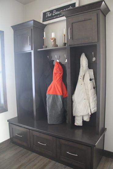 Coat storage inside stained maple lockers with matching wood bench top