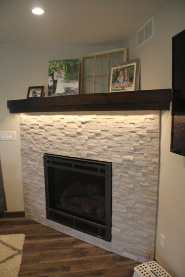 Custom stained wood mantel above bricked fireplace