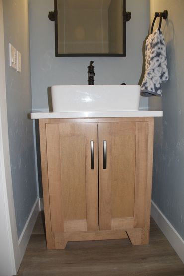 Stained English Ash maple powder room vanity with angled decorative cabinet toes