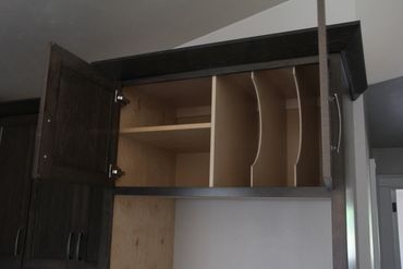 Cookie sheet storage with curved dividers above fridge