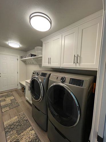 Laundry and locker hallways with deep upper cabinets above washer/dryer and sink with storage