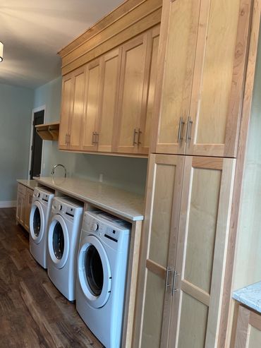 Large laundry hallway with designated washer/dryer space and countertop above for folding clothes