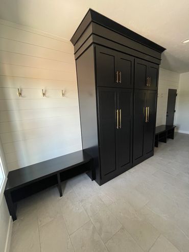 Stained black cabinetry & bench tops with tall cabinet going to the ceiling with soffit crown board 