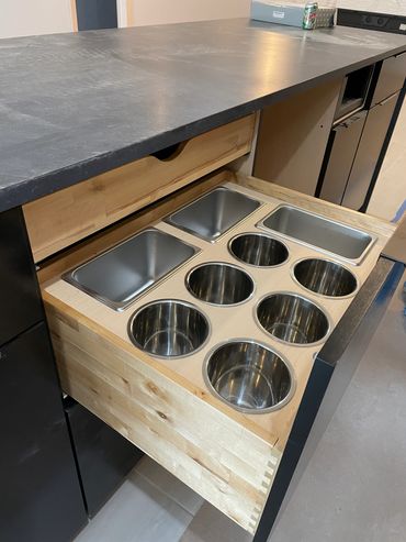 Custom deep silverware drawer with utensil storage and hidden roll-out above