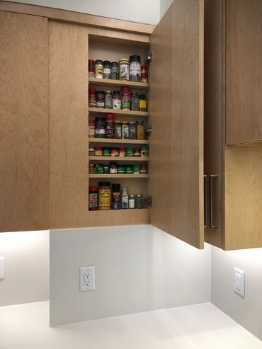 Custom spice rack hidden behind door that lines up with the rest of the cabinets