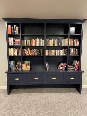 Custom blue stained bookcase with adjustable shelving and drawer storage