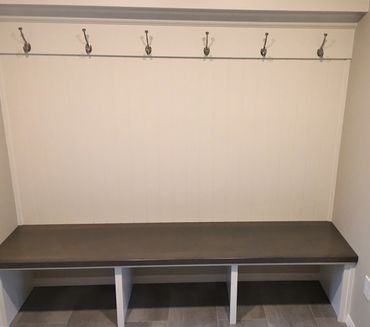 Built-in mudroom bench with hook board and decorative storage shelf above