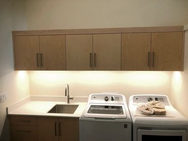 Frameless clear maple cabinetry with laundry sink