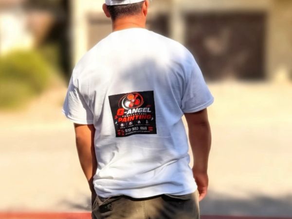Man wearing a white G-Angel Painting shirt outdoors.