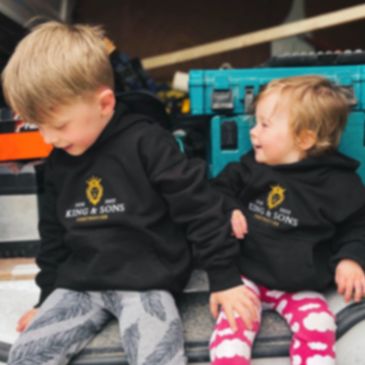 Two children wearing King & Sons jumper smiling