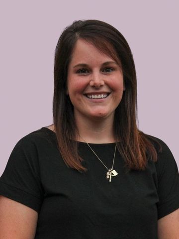 Smiling woman with straight brown hair wearing a black shirt.