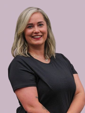 Smiling woman with blonde hair in black shirt.
